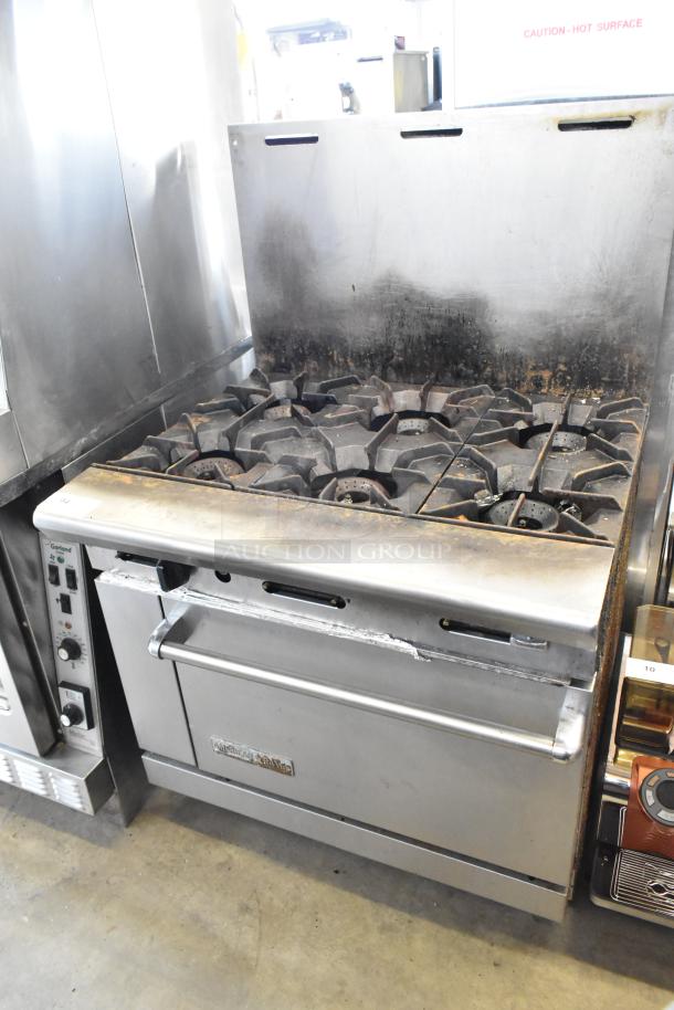 American Range commercial gas-powered six-burner range with oven and backsplash, stainless steel, used condition.