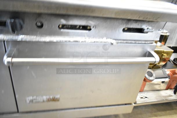 American Range commercial gas-powered 6 burner range with oven and backsplash. Stainless steel, used condition.