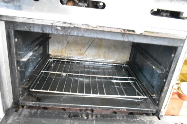 American Range commercial gas oven interior, showing a wire rack. Moderate wear, suitable for heavy kitchen use.