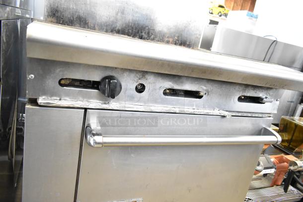 American Range commercial gas-powered 6-burner range with oven and backsplash. Features stainless steel construction, used condition.