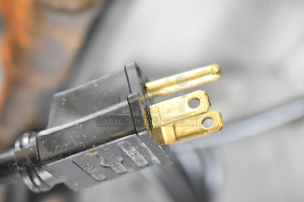 Close-up of a three-prong electrical plug for Garland MCO-GS-10S convection ovens. Visible wear on the plug's surface.