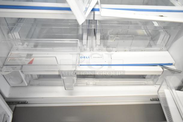 Brand new Frigidaire FRFC2323ASB reach-in cooler interior with deli drawer. Visible tags include "PurePour" and "Deli Drawer."