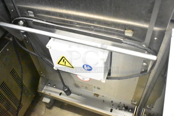 JBT 2ND-GEN-MFJ-HE citrus juicer, stainless steel, on casters, 115V, commercial use, electrical warning labels visible.