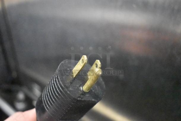 Close-up of a two-pronged U.S. power plug from a JBT 2ND-GEN-MFJ-HE citrus juicer. Black plastic casing.