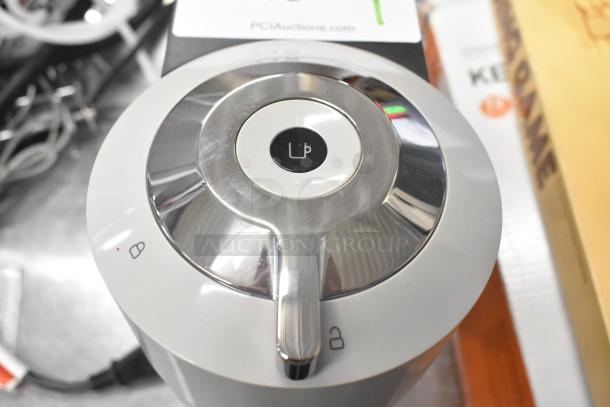 Breville BNV520GRY Nespresso espresso machine, grey, 120V, sleek design, top view. Visible lock and unlock icons.