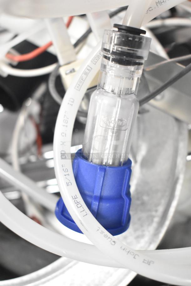 Industrial components including ballasts, blower wheel, and tubing. Features include clear and blue fittings, visible markings.