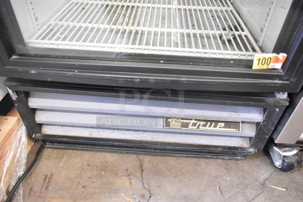 True GDM-12 commercial cooler merchandiser with single door, 115 volts, 1 phase. True logo on lower vent.