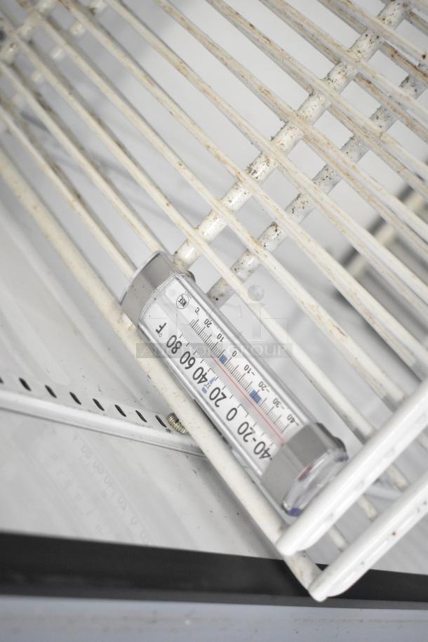 True GDM-12 cooler interior showing thermometer on wire shelves. Shelves have slight discoloration. 115V, 1 Phase.