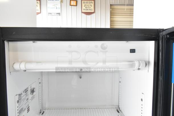 True GDM-12 commercial single door reach-in cooler merchandiser, 115 volts, interior view, featuring shelf and fluorescent light.
