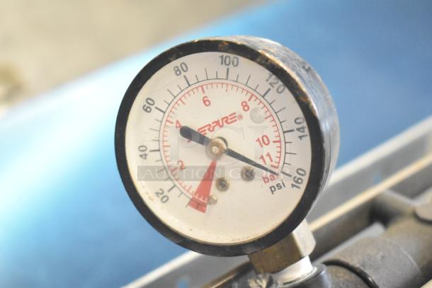 Gauge close-up, showing pressure in psi and bar with red and black markings. Slight wear visible on outer casing.