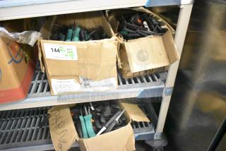 Boxes of 250 sharpened stainless steel knives, including poultry and paring knives. Includes labels showing inventory details.