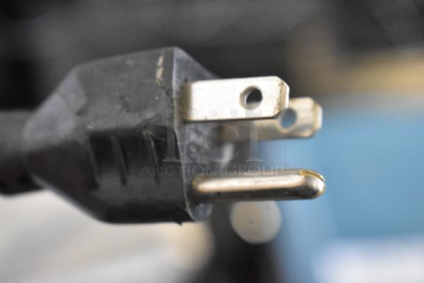 Close-up of a 3-prong plug for the 2019 Hobart HTi-LH3 Commercial Countertop Scale, showing plug's prongs and black casing.