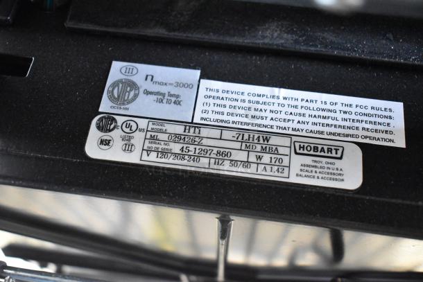 2024 Hobart HTi-7LH4W commercial scale label showing model, serial number, voltage, and compliance details. No power cord included.