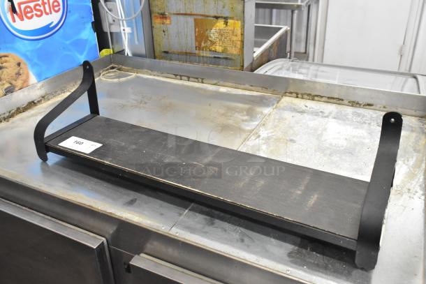 Black wall mount shelf with a rectangular wooden surface and metal brackets. Visible tag reads "160". Good condition.