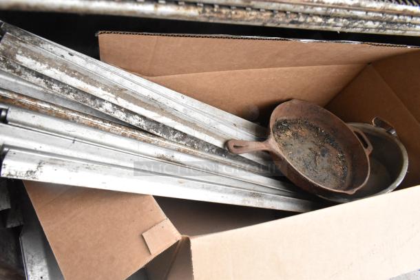 Pro Smoker 'N' Roaster 150P parts, including metal racks and pans, inside a cardboard box. Signs of wear visible.
