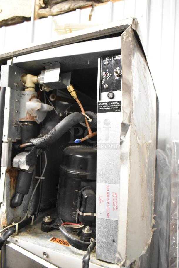 Hoshizaki KM-501MWH ice machine head on bin, 115-120V, 1 phase, interior exposed, visible labels show Arctic Glacier Inc. property.