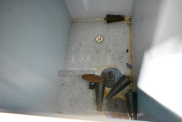 Hoshizaki KM-501MWH commercial ice machine head on bin, 115-120V, 1 Phase. Interior view showing used parts and drainage.