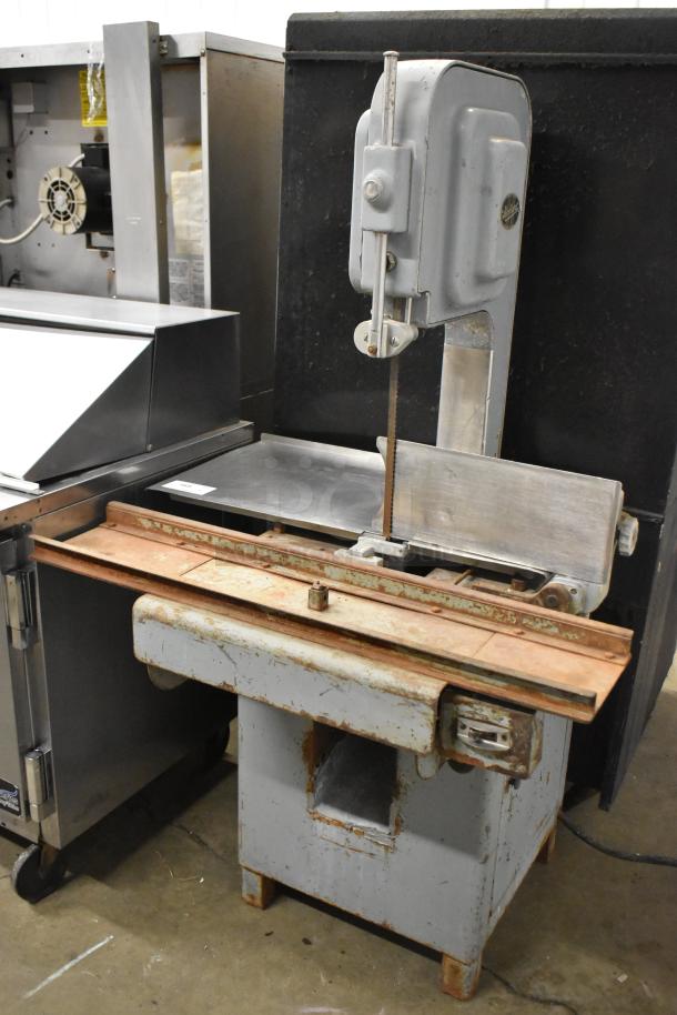 Hobart commercial floor-style meat saw, used condition, visible wear on surface. Durable metal build, equipped for large cuts.