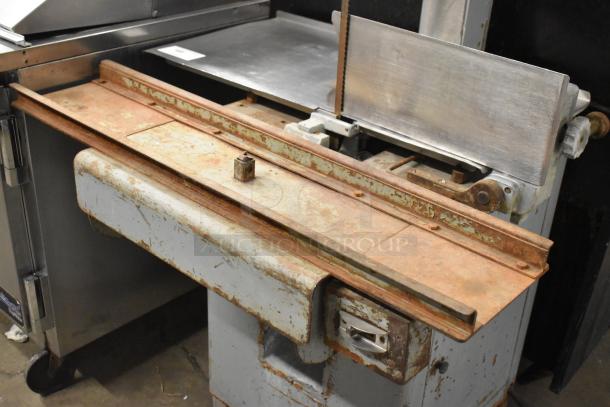Hobart Commercial Floor Style Meat Saw with metal cutting surface, showing signs of rust and wear. Ideal for industrial use.