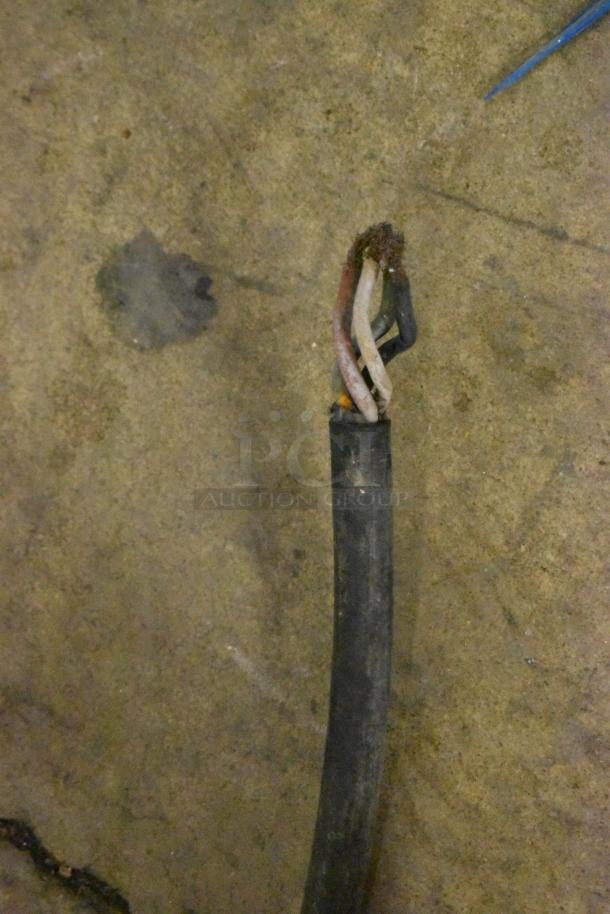 Frayed electrical cable of Hobart Commercial Floor Style Meat Saw, showing damaged wires on concrete floor.