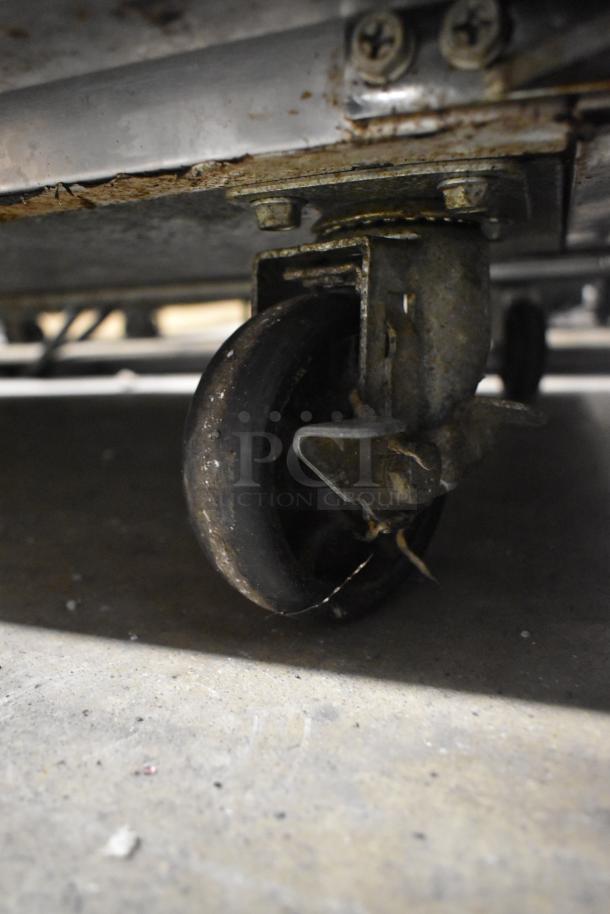 Avantco 178APT48HC prep table caster wheel, showing rust and wear on commercial caster.