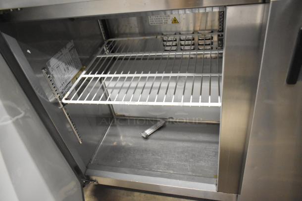 Avantco 178APT48HC sandwich prep table interior with wire shelving, stainless steel finish, and visible model label.