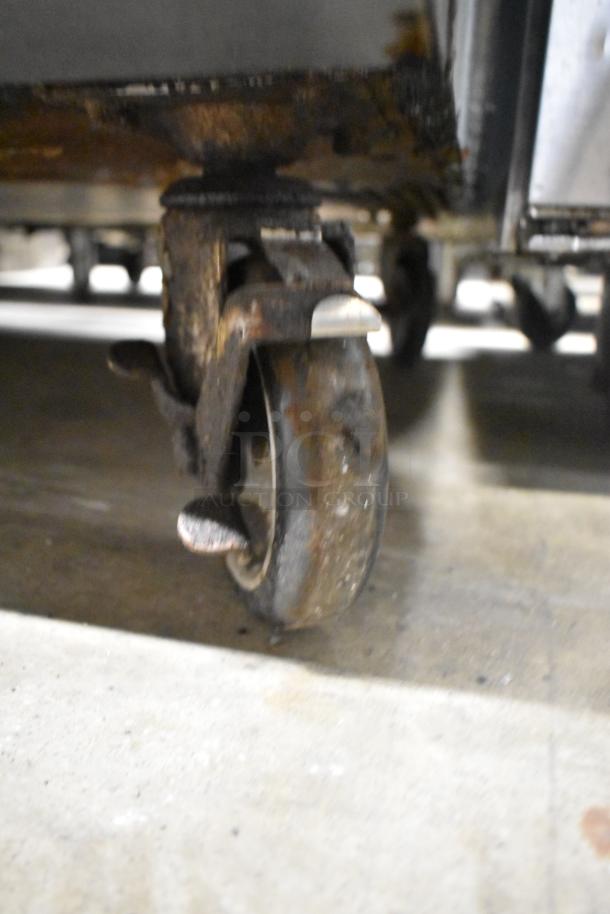 Close-up of a caster wheel from the Cooking Performance Group 351FGC100N commercial convection oven. Visible wear.