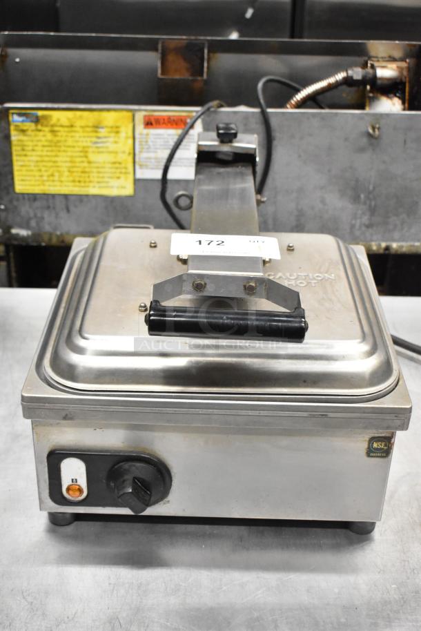 Anvil TSA 7009 countertop panini press, stainless steel, visible control knob, warning labels, in used condition.