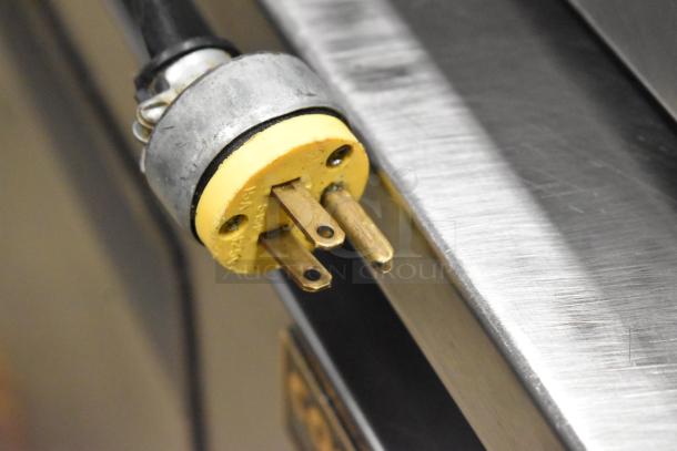 Avantco countertop refrigerated topping rail plug. 115V, 1 phase. Brass prongs, durable construction. Close-up view.