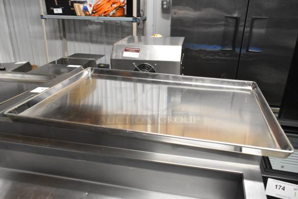 Stack of 20 metal full-size baking pans in good condition, reflecting light. Auction lot numbered 174.