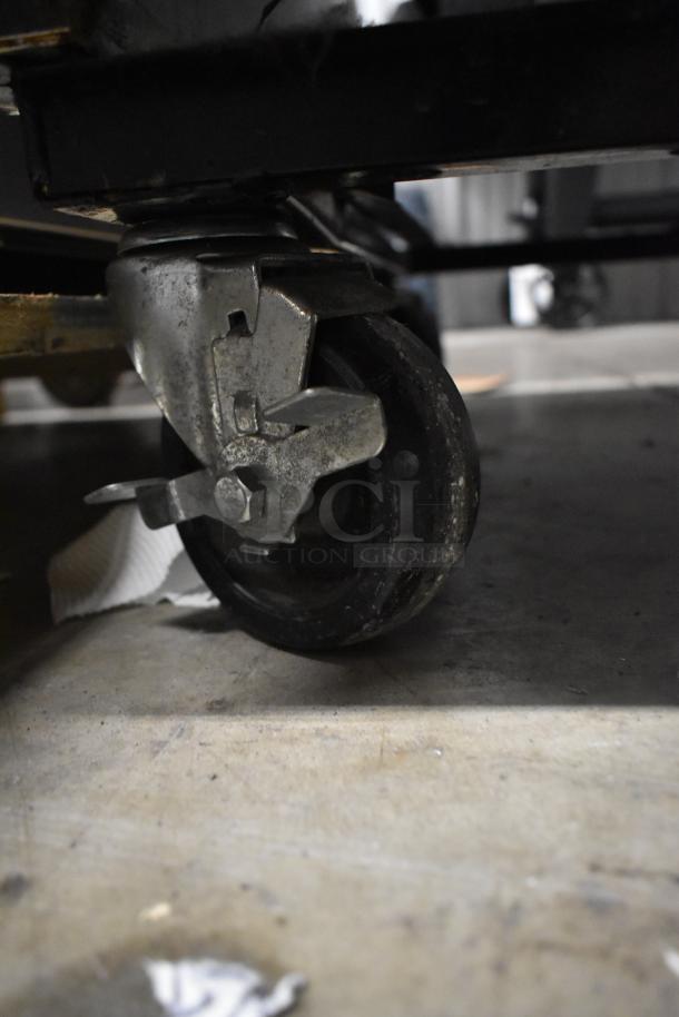2016 True T-35 commercial cooler caster. Metal and rubber construction, attached to base. Some wear visible.