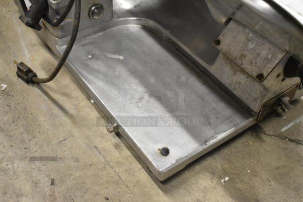 Globe commercial countertop meat slicer with blade sharpener, 115 volts, 1 phase, showing base and power cord.