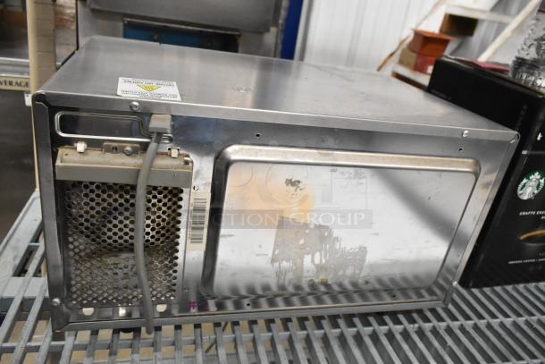 Solwave Commercial Countertop Microwave Oven, stainless steel, showing rear view with visible wear, power cord attached.