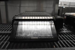 2016 Hobart HTi-LH commercial countertop scale, missing power cord, 120/208-240 volts, 1 phase, front view on shelf.