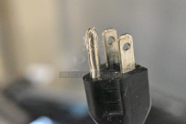 Close-up of a power plug for a 2017 Hobart HTi-7LH26 commercial countertop scale, showing three prongs.
