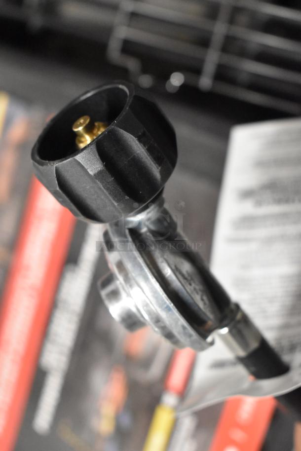 Close-up of Char-Griller Professional propane gas connector, showcasing robust metal construction and secure fitting.