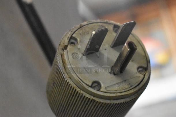 Close-up of a three-prong plug from an Alto Shaam 1000-TH oven, showing wear and voltage marking.