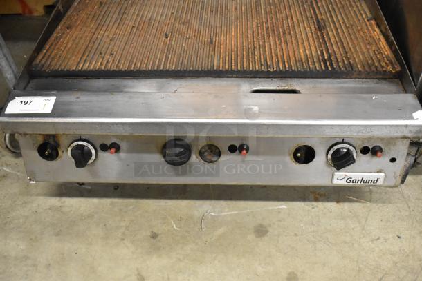 Garland Commercial Countertop Ribbed Griddle, gas-powered. Features adjustable knobs, visible wear on cooking surface.