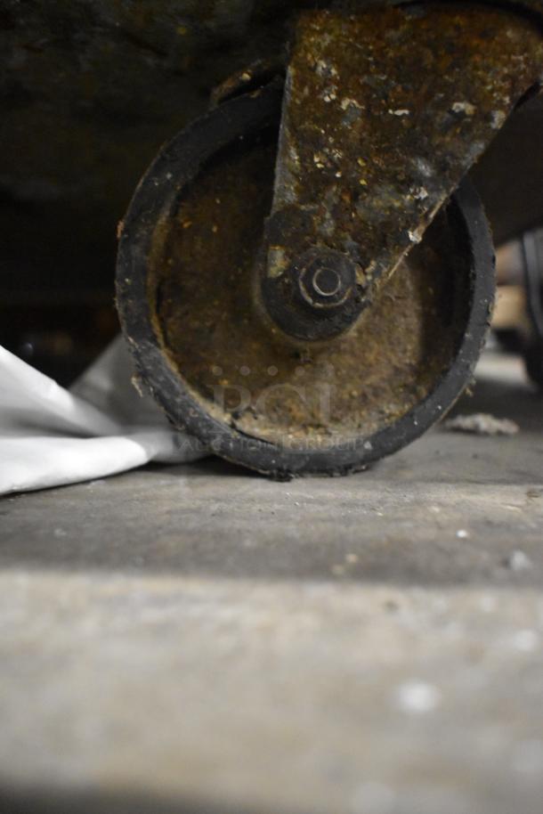 Close-up of a rusted wheel on the Continental CPA60 commercial pizza prep table on casters.