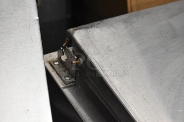 Continental CPA60 commercial pizza prep table detail, showing stainless steel surface and corner hinge. Visible wear and patina.