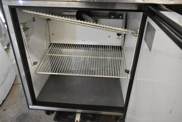 True TSSU-27-12M-B commercial sandwich salad prep table, open interior view showing shelves; visible labels on side wall.