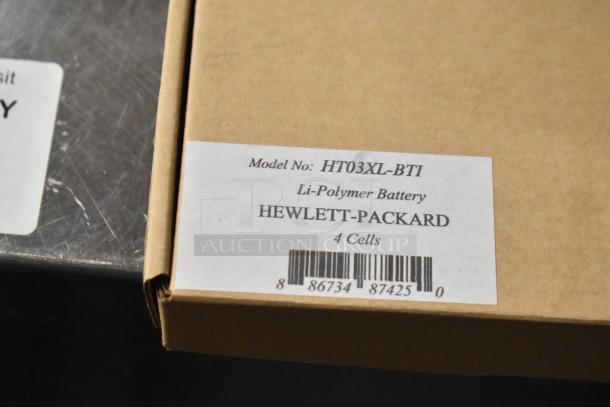 Cardboard box with label showing HT03XL-BTI Li-Polymer Battery, 4 cells, Hewlett-Packard branding, barcode visible.