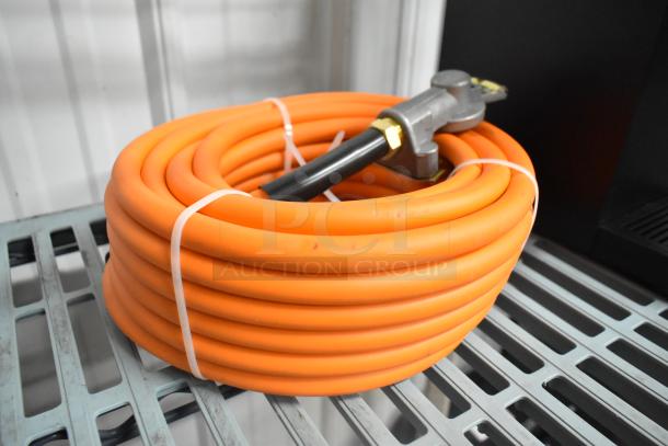 Coiled orange propane gas hose, new condition, with attached fitting. Auction includes two hoses, doubling bid value.