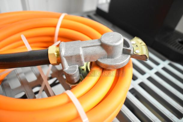 Orange propane gas hose with metal fittings, coiled neatly. Item in new condition, suitable for outdoor grilling or heating.