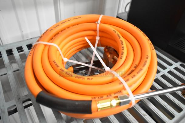 Orange propane gas hose, coiled, with 300 PSI marking, secured with zip ties, featuring metal fittings. Suitable for various uses.