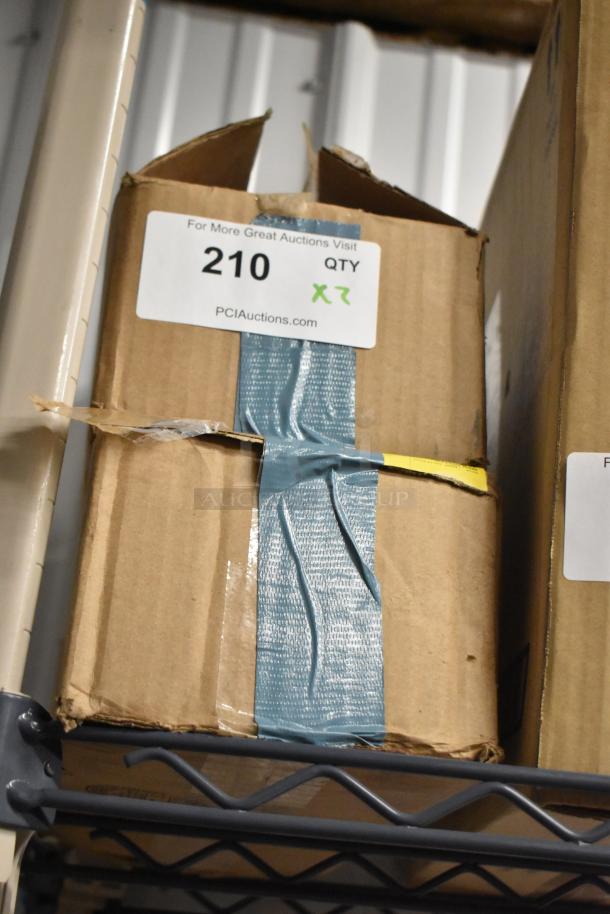 Two boxes of receipt printer rolls, taped, with auction label "210 QTY 2X," shelf-stored, showing partial wear.