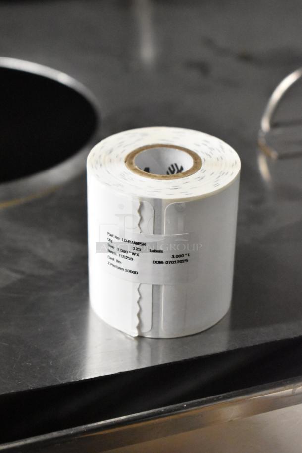 Roll of receipt printer paper on a metal surface, labeled with size 2.000"W x 3.000"L and part number LDR7ANSR.