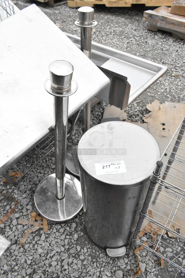 Stainless steel trash can and two stanchions. Tag reads "217 QTY x3." Ideal for event or commercial use.