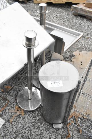 Stainless steel trash can and two stanchions. Tag reads "217 QTY x3." Ideal for event or commercial use.