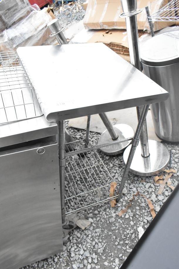 Stainless Steel Table with wire undershelf, industrial design, sturdy legs, minor wear, ideal for commercial use.